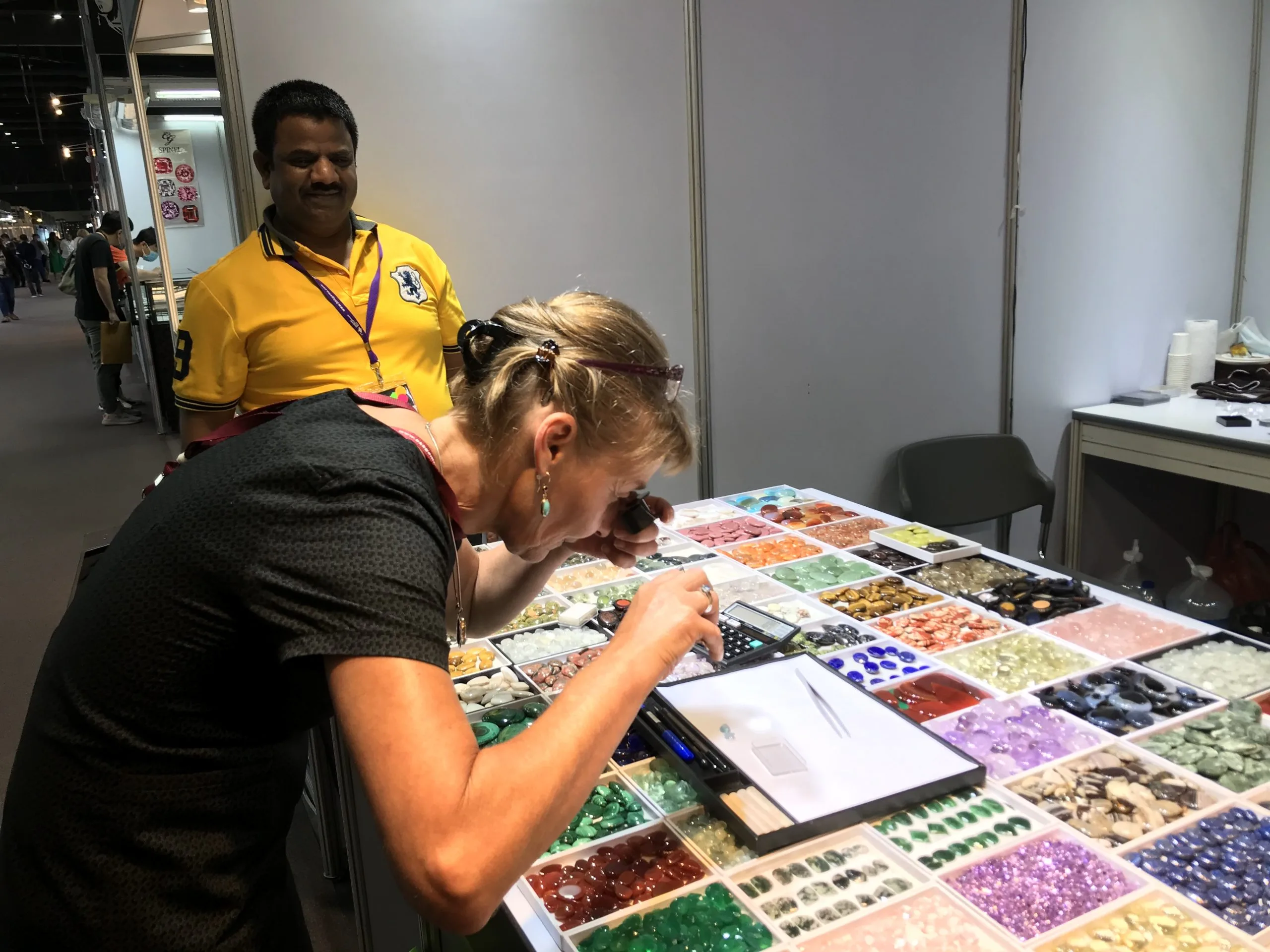 sélection de pierres précieuses et opales expert examinant des pierres précieuses et opales sur salon de gemmologie